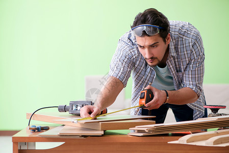 在其工作间工作的木工木匠维修厘米男人工具房子家具修理工磁带技术员地板高清图片素材
