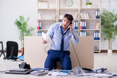 商务人士对许多电话打来感到沮丧笔记本服务台操作员人士办公室超载商业员工老板工人逾期高清图片素材