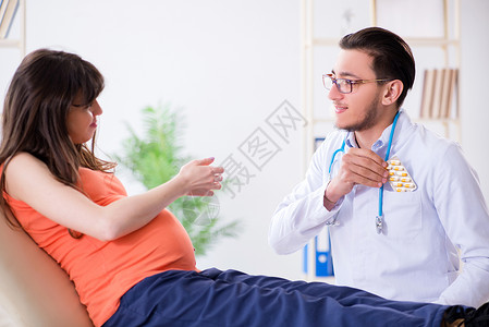 与丈夫一起到诊所看医生的怀孕妇女在诊所看医生肚子卫生咨询产科父母考试病人药片微笑访问婴儿高清图片素材