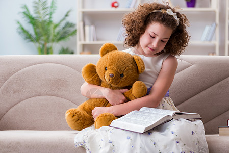 泰迪熊拥抱家里看书的小漂亮小姑娘幼儿园乐趣学习知识家庭作业阅读学生瞳孔小学生闲暇背景