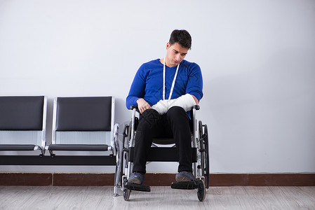 绝望的男子等待预约 在医院里 他打破了男人轮椅大厅医生游客车轮事故挫折保险访问绷带高清图片素材