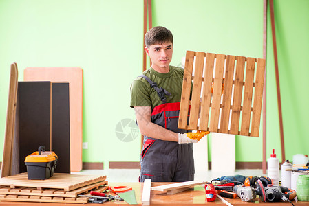 扛木头工人在工作间工作的青年木工工人木匠乐器木地板工具服务展示工匠工作台维修木头背景