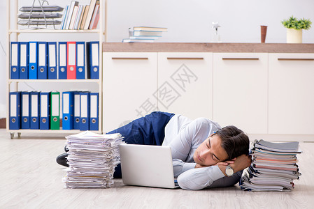 在办公室工作的非常繁忙的雇员人士实习生睡眠文件夹说谎地面经理男人职场压力堆高清图片素材