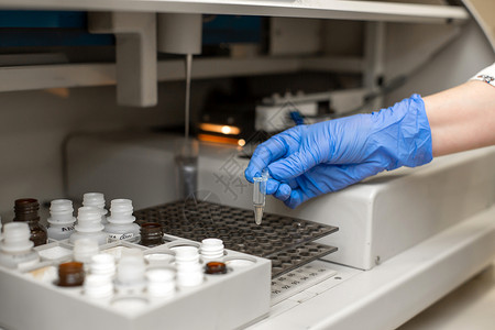 生化分析仪实验室技术员在自动血液样本分析仪中测试血液背景