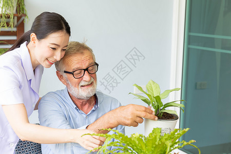 退休老人和护士正在给一家小工厂浇水 而植物男人房子魅力老年父亲闲暇园艺花朵后院生活高清图片素材