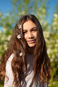 在一个盛开的春季绿花园里 一个年轻美丽的少女女孩的肖像洗发水幸福花园黑发季节公园头发晴天女性女士春天高清图片素材