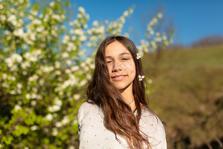 在一个盛开的春季绿花园里 一个年轻美丽的少女女孩的肖像洗发水头发冒充幸福女士公园晴天季节花园情感自然高清图片素材