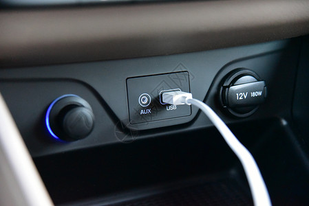 将USB电缆连接到汽车仪表板上的USB港口背景图片