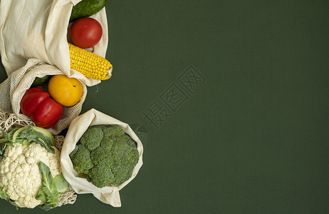 绿色表面生态袋中的蔬菜 带有复制空间 胡椒 西红柿 玉米 黄瓜 西兰花 花椰菜 装在可重复使用的购物环保棉布袋中 零废塑料免费概背景图片