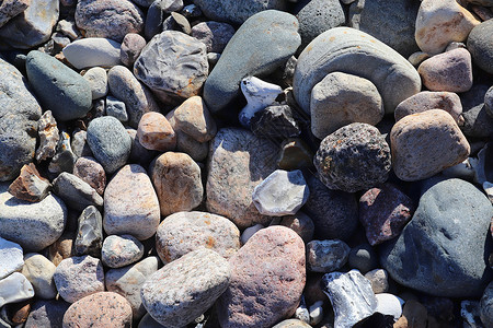 美丽的石头石块碎片 在无海平面的海滩上花岗岩材料岩石团体鹅卵石矿物地面碎石海岸卵石背景图片