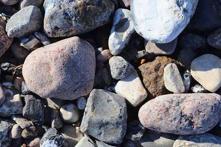 美丽的石头石块碎片 在无海平面的海滩上卵石碎石材料矿物地面海岸海洋团体花岗岩宏观背景图片