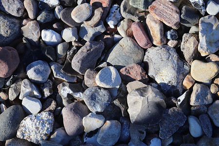 美丽的石头石块碎片 在无海平面的海滩上团体鹅卵石支撑材料岩石矿物宏观地面海岸花岗岩背景图片