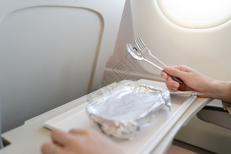 人下飞机素材飞机上装着食品盘子 在Ec上服餐的妇女班级假期航空公司飞行早餐服务午餐食物喷射托盘背景