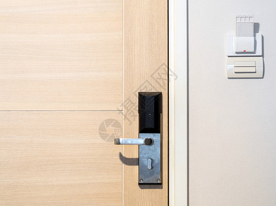 配有现代把手设备和钥匙卡插卡的木制门高清图片