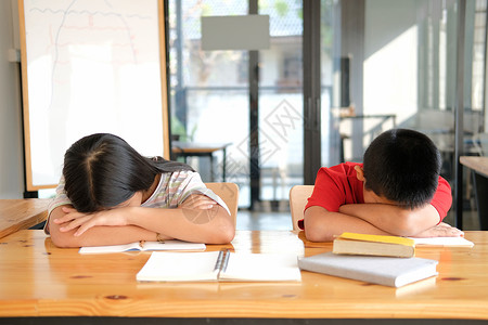 在图书馆深考后睡觉的已累累 精疲力竭的女学生学习学校教育学生睡眠考试女孩疲劳高清图片素材