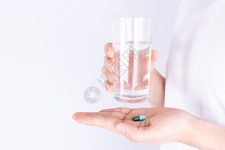 握着一杯水和药丸药物的紧握手 保健和药房概念 掌声疼痛营养药片剂量药品病人抗生素棕榈胶囊止痛药背景图片