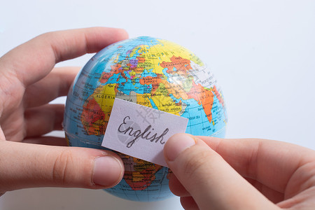 手持全球使用英文文字的纸上随笔纸班级语法世界教育语言字典地球知识全球化指导学生高清图片素材