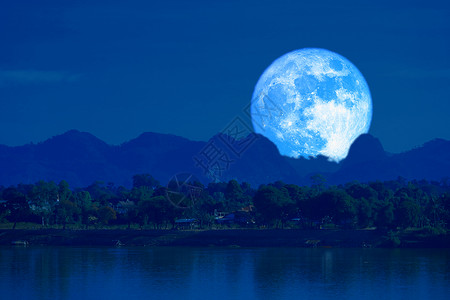 蓝月亮向后升起 在夜空中的银色云雾模糊高清图片