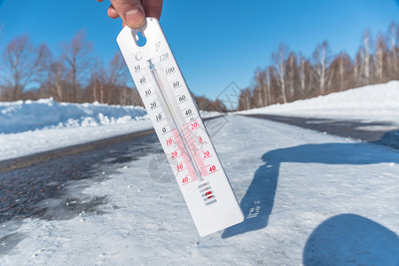 低温温度计在结冰的道路或高速公路的背景下 温度计在寒冷的天气中显示出负温度 低温和冰的恶劣天气条件 冰雪覆盖的道路或高速公路背景
