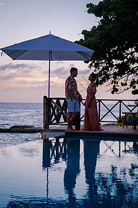 库拉索Curacao 在Curacao度假的夫妇 在Curacao看池边日落旅行游泳蜜月假期热带旅游夫妻海滩阳光游泳池背景