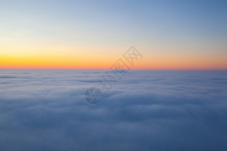 云巅之上超奇异的日出在山顶云层之上航班晴天橙子天气旅行飞机空气太阳天空日落背景