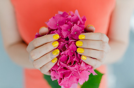 黄黄色有修指甲的妇女拿着一朵花美甲师美甲店工作室情感手足粉色护理沙龙保养美甲背景图片