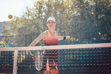 穿红运动服打网球的妇女俱乐部火车运动装女士微笑教训球拍网球训练玩家背景图片