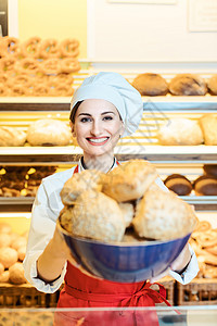 面包店一位有吸引力的年轻售卖妇女赠送的新面包柜台奉献食物商业服务馒头包子传统零售工作服提供高清图片素材