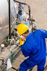 在机器中工作的工业工人技术员男人金属工厂作坊员工安全植物机械技术在职的高清图片素材