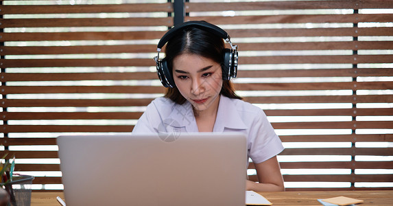 年轻美少女使用膝上型计算机学习或创业者在家中用笔记笔记和笔记电脑工作学生高清图片素材