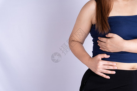女性触摸腰部或肝脏位置的手与灰色背景隔绝肝炎高清图片素材
