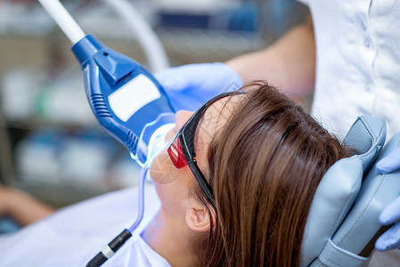 白牙闪光微笑紫外牙医光线防护眼镜白色水平激光牙科设备病人背景图片