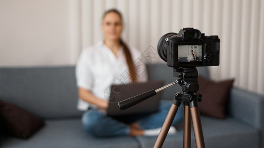 博客在室内录制视频 有选择性地聚焦于摄像显示闲暇商业重点相机订户博主女性研讨会技术成人自我分享高清图片素材