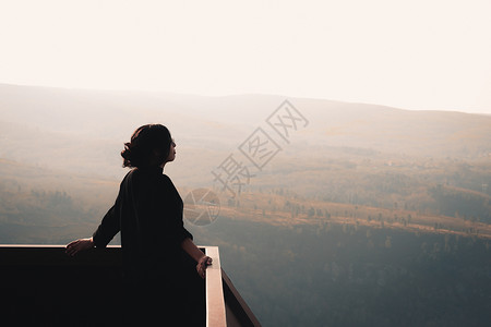 一位站在大山前的年轻女子 在阳光明媚的日间幸福与自由概念中 望着地平线微风娱乐信仰火山天堂女士房间外表头发思维背景图片