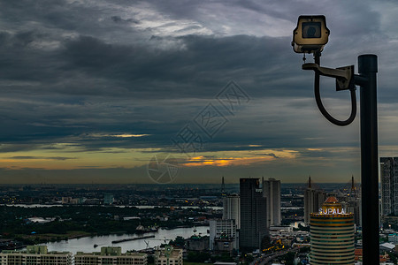 闭路电视监控 安保摄像头 晚上在城市和Chao Phraya河的观察下进行回击背景图片