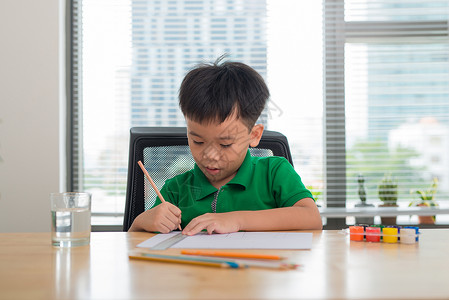 可爱的男孩在用彩色铅笔画画作业孩子童年家庭白色写作桌子学习教育学校幼儿园高清图片素材