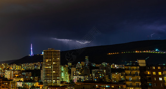 第比利斯的夜间风暴建筑学手电筒天空地标蓝色背景闪光背景图片