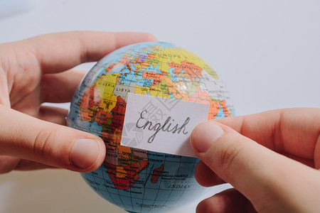 手持全球使用英文文字的纸上随笔纸说话英语教育语言学指导字典学生班级发音学校文化高清图片素材
