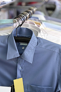 男子在零售商店的衣架上涂着男子衬衫精品男人蓝色购物团体套装棉布西装销售时尚背景图片