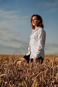 快乐的年轻女子穿着白衬衫 在小麦田里 阳光明媚的日子金发女郎女孩农业雀斑场地乐趣衬衫身体幸福女性美丽的高清图片素材