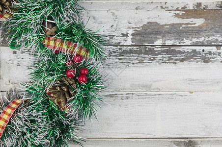 木制仿古背景平躺的圣诞花环 传统的圣诞花环 上面有红色浆果和装饰品 松果和木头上的棉花桌子乡村风格装饰假期松树卡片花圈锥体艺术季节高清图片素材