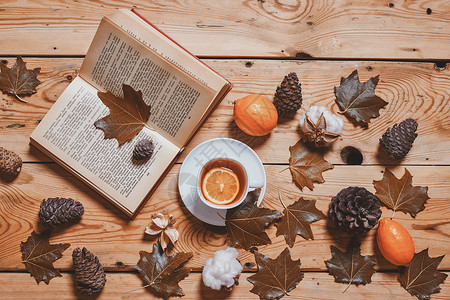 一本书一杯茶在舒适的秋天阅读一本书桌子闲暇季节柠檬橙子叶子落叶享受休假饮料背景