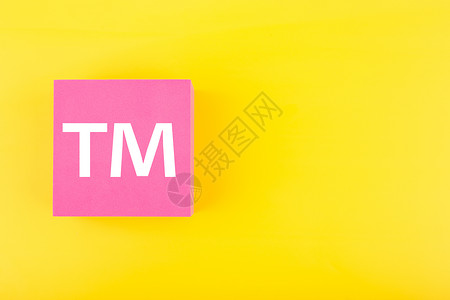 TM 商标在黄色背景上的粉红色图形上签名 带有复制空间水平法律金融联盟服务专利执照字母财产咨询限制高清图片素材