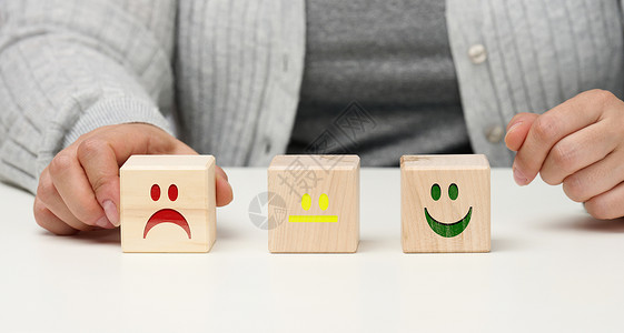 具有不同情绪的木块 从微笑到悲伤和女人的手 评估产品或服务质量 情绪状态 用户评论的概念顾客评分审查立方体商业蓝色情感客户速度排背景
