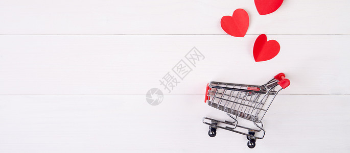 白色心形素材木桌上的购物车和心形纸 2 月 14 日节日情人节的销售概念 超市和商店 符号和庆祝活动 商业和假日销售概念大车假期礼物桌子广告背景