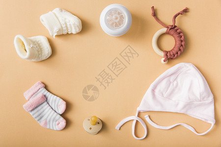 高品质奶瓶婴儿袜子一对羊毛鞋奶嘴帽奶瓶玩具橙色背景 高品质美丽的照片概念背景