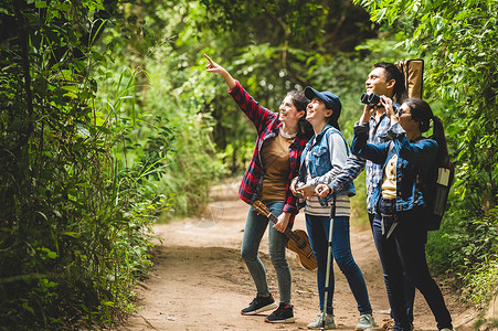 一群亚洲朋友一起冒险在森林里远足和露营 家庭旅行放松 野生动物概念中的徒步旅行和小径活动 指着树或天空的女人 复制空间木头女性远成人高清图片素材