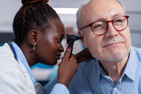 华阴老腔黑色医生用耳腔检查的眼透镜贴近黑人医生耳朵诊所治疗乐器临床药品技术耳科卫生访问背景
