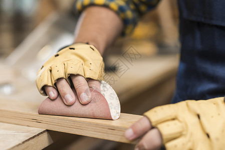 特写男性木匠用砂纸摩擦木头 高品质照片背景图片
