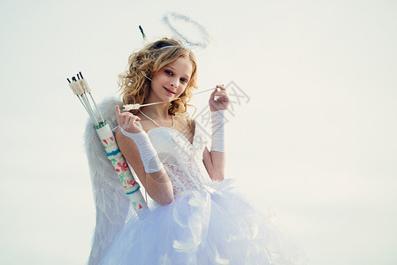 爱之箭 情人节的丘比特 少年天使 丘比特可爱的天使用弓和箭 白色裙子和翅膀的迷人卷发小女孩-天使丘比特女孩背景图片